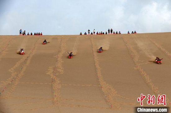 6月13日，敦煌鳴沙山月牙泉景區(qū)舉辦滑沙比賽。　張曉亮 攝
