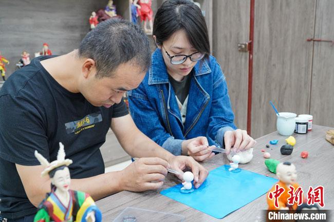 <a target='_blank'  data-cke-saved- >中新社</a>記者(右)現(xiàn)場體驗(yàn)面塑制作過程?！￡悹帍?qiáng) 攝