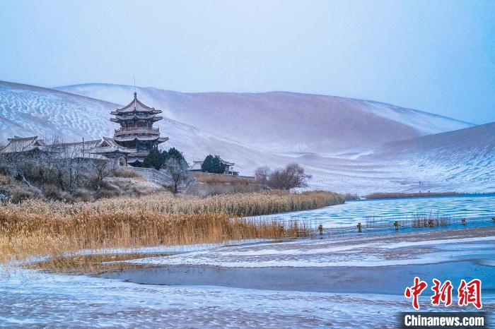 2021年11月28日，雪落鳴沙山月牙泉景區(qū)?！⊥醣筱y 攝
