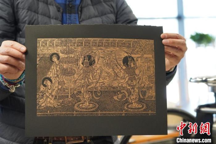 圖為手工書藝人展示敦煌雕版壁畫印刷品?！【琶赖┰?　攝