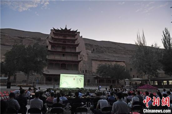 2018年8月，在敦煌莫高窟標(biāo)志性建筑“九層樓”前，《回顧平山郁夫先生的貢獻(xiàn)》座談會(huì)舉行。來自中日兩國的專家、學(xué)者共同懷念這位情系敦煌數(shù)十載的繪畫巨匠、中日友好的文化使者、世界文化遺產(chǎn)的守護(hù)者。中新社記者 楊艷敏 攝