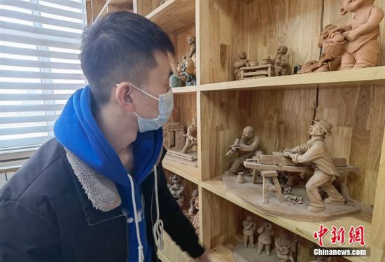 圖為學(xué)生欣賞泥塑作品。 劉玉桃 攝