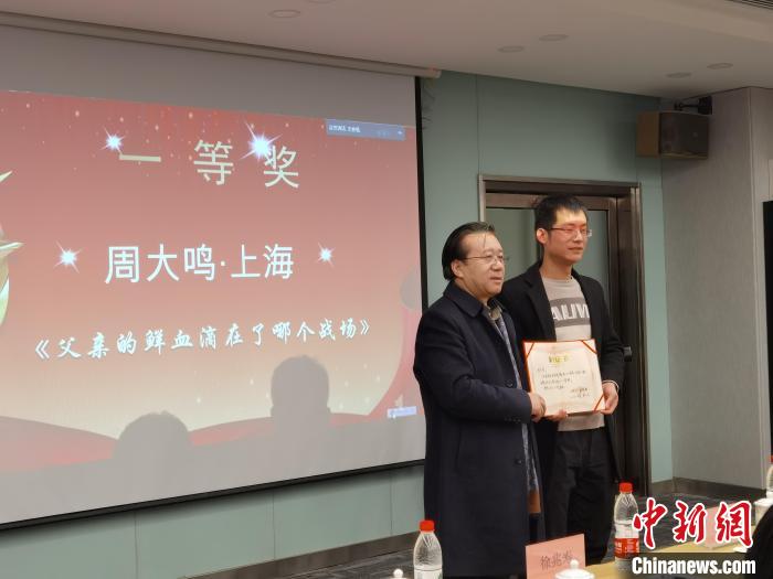 圖為作家、西北師范大學(xué)新聞與傳媒學(xué)院院長徐兆壽頒發(fā)一等獎證書，代領(lǐng)獎?wù)呱吓_領(lǐng)獎?！钅?攝