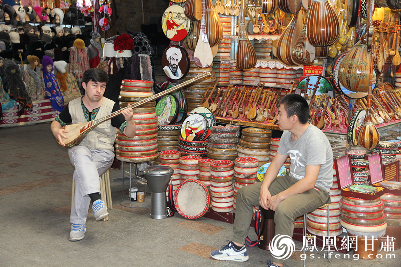 烏魯木齊二道橋巴扎內(nèi)，店主正在向客人展示樂器。楊文遠(yuǎn) 攝