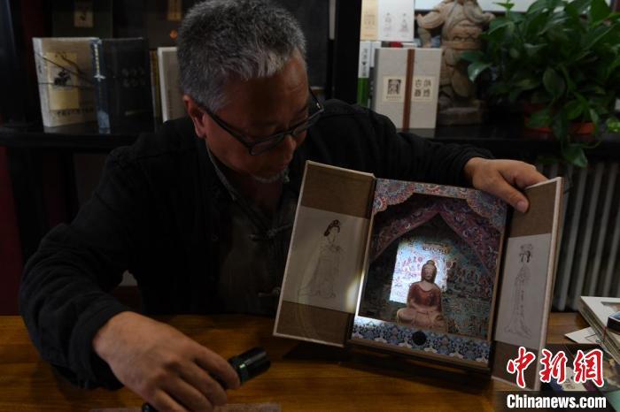 圖為讀者出版集團讀者晉林工作室獨立出品人徐晉林，展示互動性強的敦煌題材手工書。(資料圖) 楊艷敏 攝
