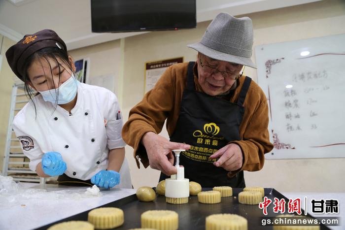 當日，受邀參加活動的臺胞臺屬代表、兩岸婚姻及子女、在甘臺商代表等歡聚一堂。圖為77歲的在甘臺胞潘天鑒制作月餅。九美旦增 攝