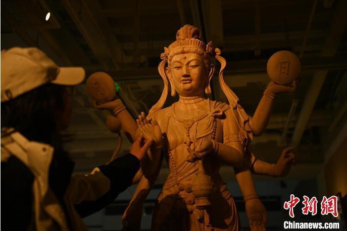 圖為季茂杰觀察自己創(chuàng)作的敦煌木雕。李亞龍 攝</p>
<p>