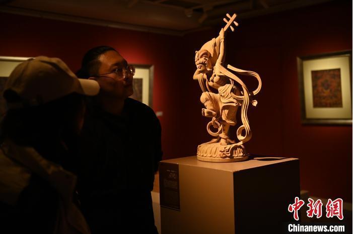 圖為季茂杰向參觀者介紹自己創(chuàng)作敦煌木雕的過程。李亞龍 攝</p>
<p>