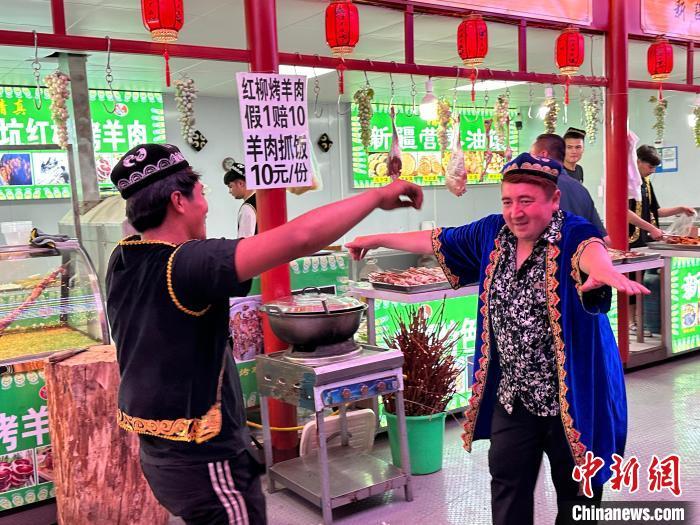 圖為餐飲經營者在“西涼不夜城”跳起舞蹈引客?！〈魑牟?攝</p><p>