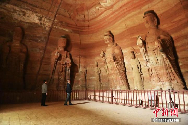 7月15日，游人參觀甘肅省平?jīng)鍪袥艽h百里石窟長廊中的南石窟寺1號窟。百里石窟長廊位于涇川縣境內(nèi)，由512個(gè)石窟、5眼窟中石井組成，現(xiàn)存王母宮石窟、鳳凰山石窟、南石窟寺、丈八寺石窟、羅漢洞石窟、太山寺石窟等規(guī)模較大的石窟群，還有數(shù)量眾多的小石窟群。南石窟寺開鑿于北魏永平三年，其中1號窟屬于大型七佛窟，七佛高達(dá)6米。中新社記者 李亞龍 攝
